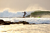Surfers riding a wave, Praia, Santiago, Cape Verde