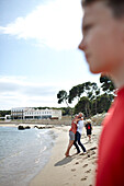Familie am Strand vor Hostal Spa Empuries, Platja del Portitxol, Girona, Costa Brava, Spanien