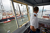 Captain on the bridge of a container ship, Rotterdam harbor, South Holland, Netherlands