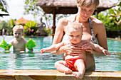 Mutter und Tochter baden im Swimming Pool, Baby 5 Monate alt, Sohn 3 Jahre alt, Schwimmflügel, schwimmen lernen, Elternzeit in Asien, Europäer, Deutsche, Westler, Familie, MR, Ubud, Bali, Indonesien