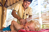 Little boy getting back massage, Balinese masseur, boy 3 years old, wellness, hotel, intercultural contact, meeting local people, locals, Balinese holiday resort, family travel in Asia, parental leave, German, European, MR, Sidemen, Bali, Indonesia
