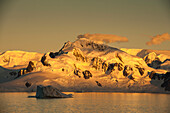 Eisbedeckte Berge bei Sonnenuntergang, Lemaire Kanal, nahe Grahamland, Antarktis
