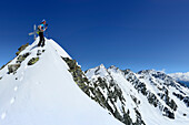 Skitourengeherin steht am Gipfel der Fünften Hornspitze, Hornspitzen und Schwarzenstein im Hintergrund, Zillertaler Alpen, Ahrntal, Südtirol, Italien