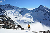 Frau auf Skitour steigt zum Piz Buin auf, Hintere Jamspitze und Piz da las Clavigliadas im Hintergrund, Silvretta, Unterengadin, Engadin, Kanton Graubünden, Schweiz