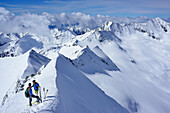 Zwei Skitourengeher stehen am Grat des Großen Möseler, Hoher Weißzint und Hochfeiler im Hintergrund, Zillertaler Alpen, Südtirol, Italien