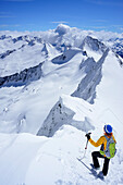 Skitourengeherin steht am Schneegrat des Großen Möseler, Schwarzenstein, Dritte Hornspitze und Turnerkamp im Hintergrund, Zillertaler Alpen, Südtirol, Italien
