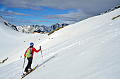Female back-country skier ascending to hut Eisbruggjochhuette, Hoher Weisszint, Zillertal Alps, South Tyrol, Italy