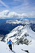 Frau auf Skitour steigt zur Fünften Hornspitze auf, Gelenknock im Hintergrund, Zillertaler Alpen, Ahrntal, Südtirol, Italien