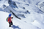 Frau auf Skitour blickt auf steile Schneeflanken hinab, Schlieferspitze, Venedigergruppe, Nationalpark Hohe Tauern, Salzburg, Österreich