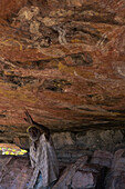 Aboriginal guide explaining the story of traditional wall paintings, Arnhem Land, Northern Territory, Australia