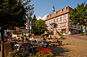 Menschen sitzen vor einem Café am Marktplatz mit Rathaus, Bad Zwesten, Nordhessen, Hessen, Deutschland, Europa