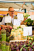 Ein Markthändler bietet sein Gemüse am Pescaria Fisch- und Gemüsemarkt am Canal Grande an, Venedig, Venetien, Italien, Europa