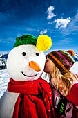 Girl kissing a snowman, Planai, Schladming, Styria, Austria