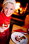 Young woman enjoying a glass of wine at dinner