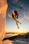 Skifahrer springt über eine Wechte in der Mitternachtssonne, Lyngenalpen, Troms, Norwegen