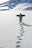 Snowboarder mit Schneeschuhen steigt auf, Skigebiet Corralco, Lonquimay, Araukanien, Chile