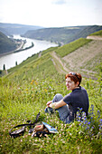 Woman resting in a meadow above Rhine Gorge, Sankt Goarshausen, Rhineland-Palatinate, Germany