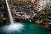 Waterfall inside rock's walls, with wonderful emerald lake, Maira valley, Piedmont