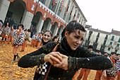 A woman attacks the opposition during the orange battles of Ivrea, Italy.