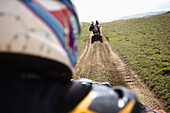View from the back of a rider of group of man riding their quads through a dirt road from Catemaco to Coatzacoalcos in Veracruz, Mexico.