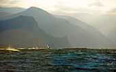Two windsurfers enjoy the last light streaming down the Columbia River Gorge.