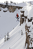 A male skier jumps off a cliff in the Wyoming Backcountry.