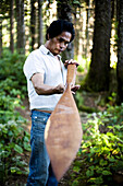 TOFINO, BRITISH COLUMBIA, CANADA. A man native to Vancouver Island checks out his hand carved paddle.