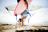 Surfers head towards the ocean to take on the massive waves a day before the 25th Eddie Aikau Big Wave Invitational. The biggest swell on the North Shore for 10 years brought 30-50 foot waves at Waimea Bay, Hawaii.