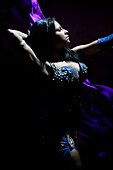 'A belly dancer dressed in a traditional costume whirls a strip of chiffon as she performs.    Belly dance is a Western-coined name for a traditional Middle Eastern dance. The term ''Belly dance'' is a misnomer as all parts of the body are involved in the
