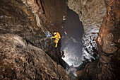 Two male British cave explorers rappel down the Grand Cascade deep underground in the main gallery of the classic famous cave in France called The Gouffre Berger high in the Vercors region.