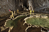 A team of British cave explorers move around the rims of these giant gour pools in The Hall of the Thirteen chamber, in the classic famous cave in France called The Gouffre Berger high in the Vercors region.