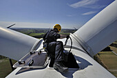 A technician climbs out of a hatch on the nacelle of a wind turbine in Germany.