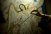 An artist paints Saint Michael, the Archangel, in Casa de los Frailes hotel in Oaxaca, Mexico.
