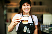 Woman holding a coffee at a Nespresso taste event.