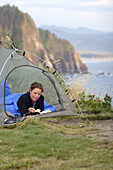 Nicole Black  writing in journal in camp along the Oregon Coast. Oswald West State Park, OR