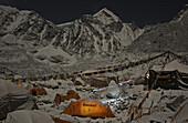 A climber's headlamp streaks through a night scene at Everest's Khumbu Basecamp, Nepal.