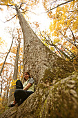 Rose Cowles sitting at the base of an old-growth poplar tree on the Boogerman Loop trail in the Cataloochee area of the Great Smoky Mountains National Park, NC