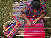 Antigua, Guatemala.: 3/25/06.  A woman from an indigenous community in Guatemala weaving while wearing an indigenous dress at work in Antigua, Guatemala. Photo by David H. Wells/Aurora Photos