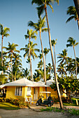 Punta Cana, Dominican Republic - April 11: Palm trees wave in the breeze above a parked golf cart and cabana at the Punta Cana Resort in the Dominican Republic, April 11, 2007.