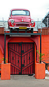Bright red, old model car with license plates saying Havanna sits above the entrance to a restaurant in Gaborone, Botswana. Gaborone is the capital city of Botswana, and is considered one of the fastest growing cities in Africa.