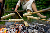 Food on skewers is cooked over a campfire in Denmark.
