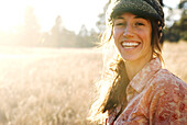 FLAGSTAFF, AZ-OCTOBER 26: Carrie Cooper, backlit and smiling, poses for a portrait in a large field of grass and trees near Flagstaff, Arizona. Photo by Kyle George/ Aurora