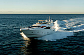 The motor yacht Alani a Sunseeker 82 in the bay of Sydney during the sunrise on this way to the ocean.