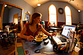 Lydia McDonald checks her email via laptop while eating breakfast at the Cathedral Cafe in downtown Fayetteville, WV