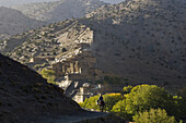 A man on horseback approaches the dramatic Berber village of Rougoult in the M'Goun Massif, Central High Atlas Mountains, Morocco on November 4, 2007.