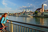 Radfahrerin blickt über die Donau auf Passau, Niederbayern, Bayern, Deutschland