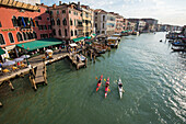 Drei Kajakfahrer auf dem Canal Grande vor der Rialto Brücke, Venedig, Italien