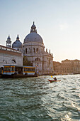 Paddler in front of historic church Il Redentore on Canal Grande, Venice, Italy