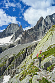 Frau beim Wandern mit Piz Badile im Hintergrund, Sentiero Roma, Bergell, Lombardei, Italien