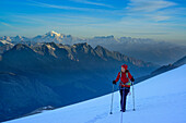 Woman roped ascending on glacier towards Gran Paradiso, Mont Blanc in background, Gran Paradiso, Gran Paradiso Nationalpark, Graian Alps range, valley of Aosta, Aosta, Italy